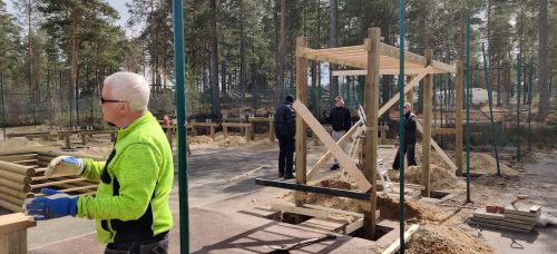 Personer som jobbar/pratar med varandra. Monkey-bars str hopmonterad och nedstlld i hl som ska gjutas.
