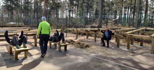 Tv personer testar varsin bnkpressmaskin, en annan testar knbjen. En fjrde person gr med ryggen mot kameran.